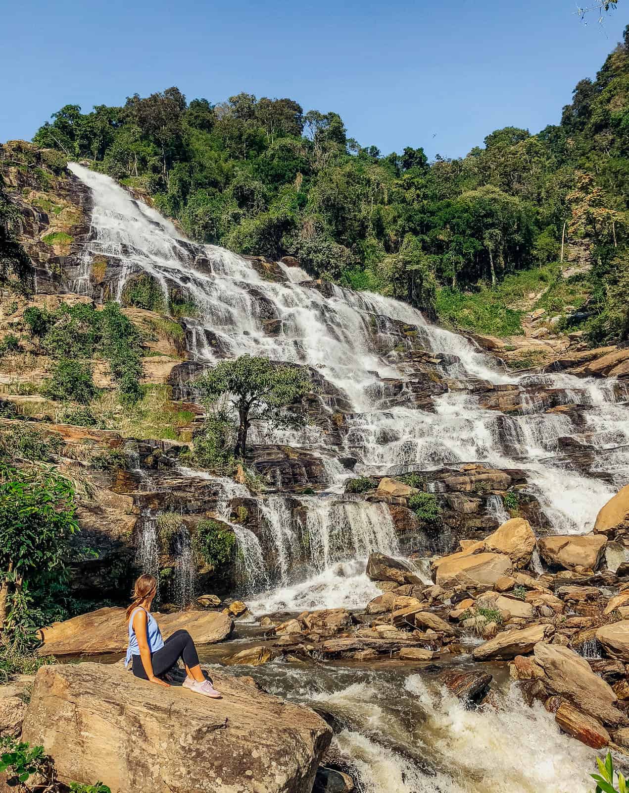 Sitting on the rocks in front of a waterfall at Doi Inthanon national park in Chiang Mai