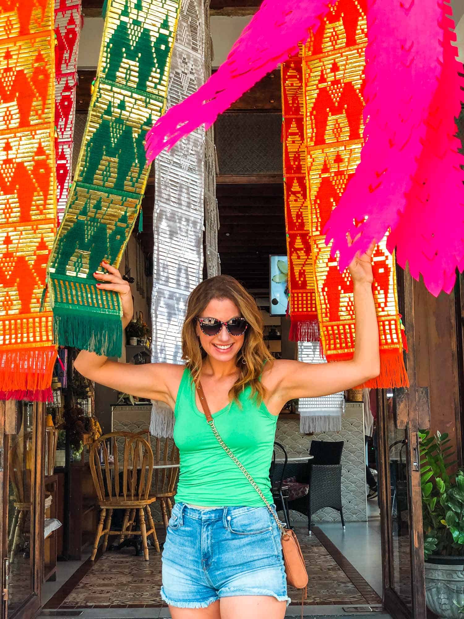 Walking through colorful hanging fabric at a store in Nimman, during 4-day Chiang Mai itinerary