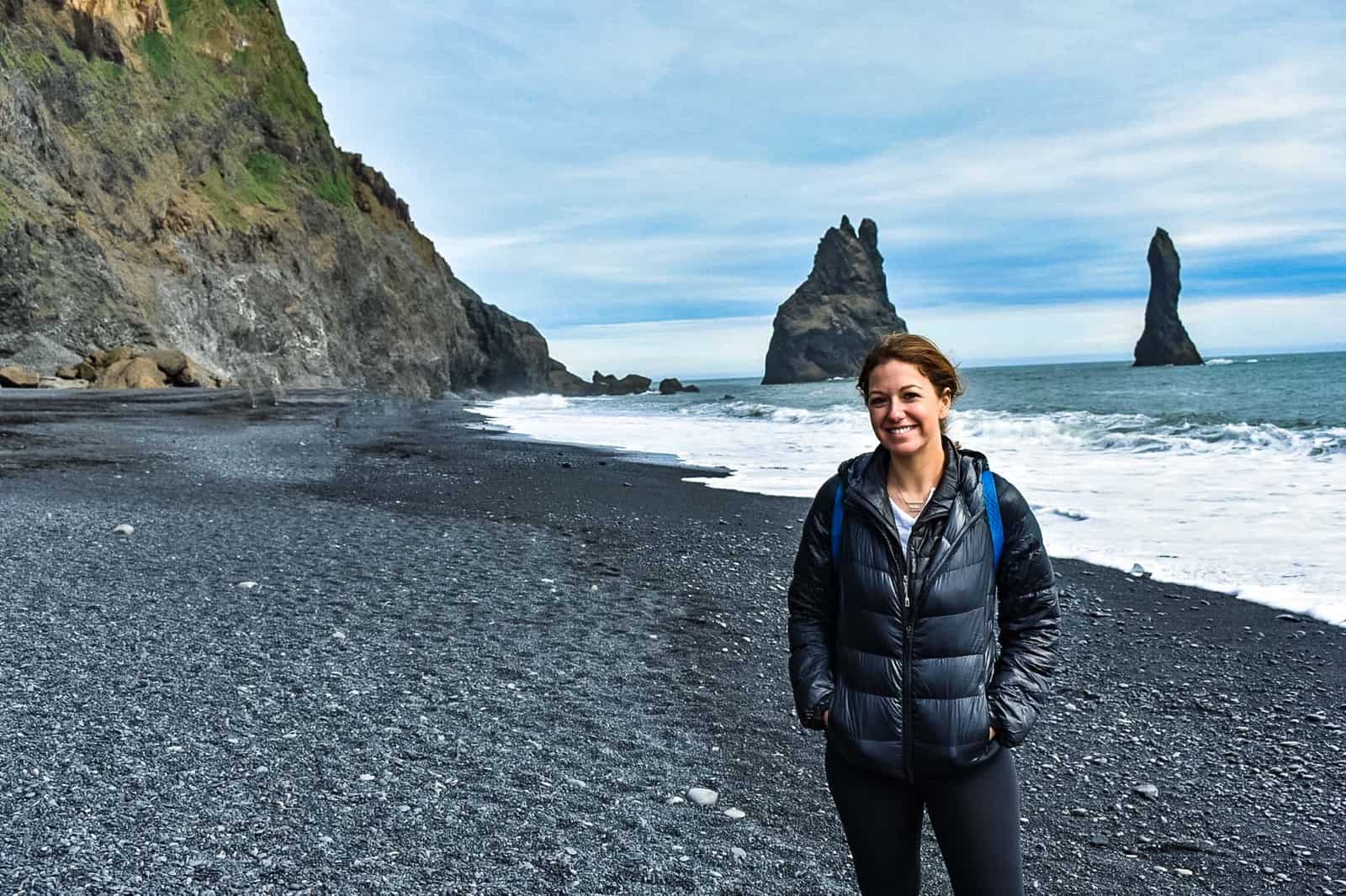 Woman standing on Vik's Black Sand Beach in Iceland