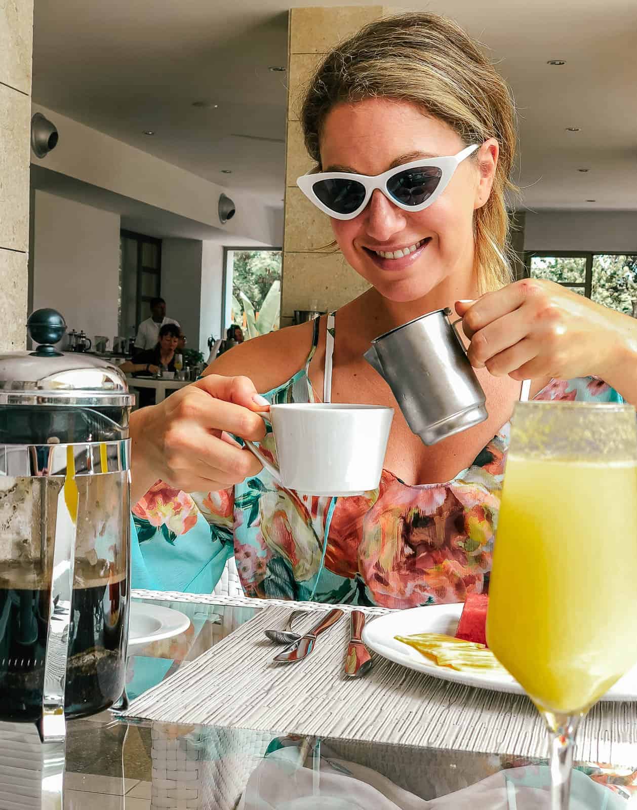 Woman pouring a cup of coffee at a brunch restaurant. 