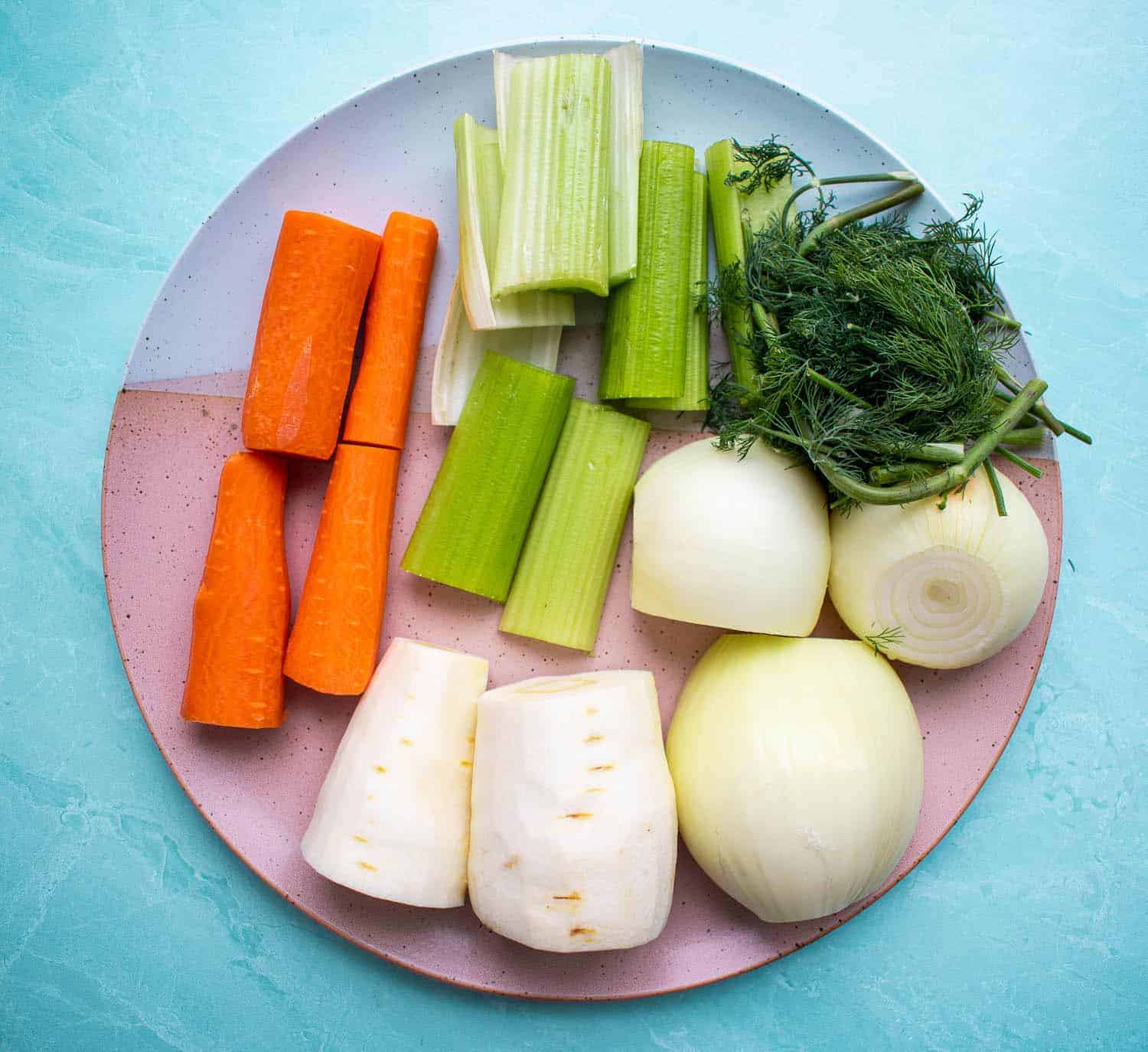Plate of raw vegetables cut up to put into a homemade stock