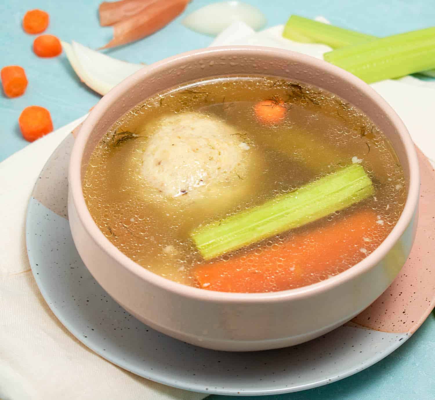 Bowl of homemade matzo ball soup with carrots, celery and chicken