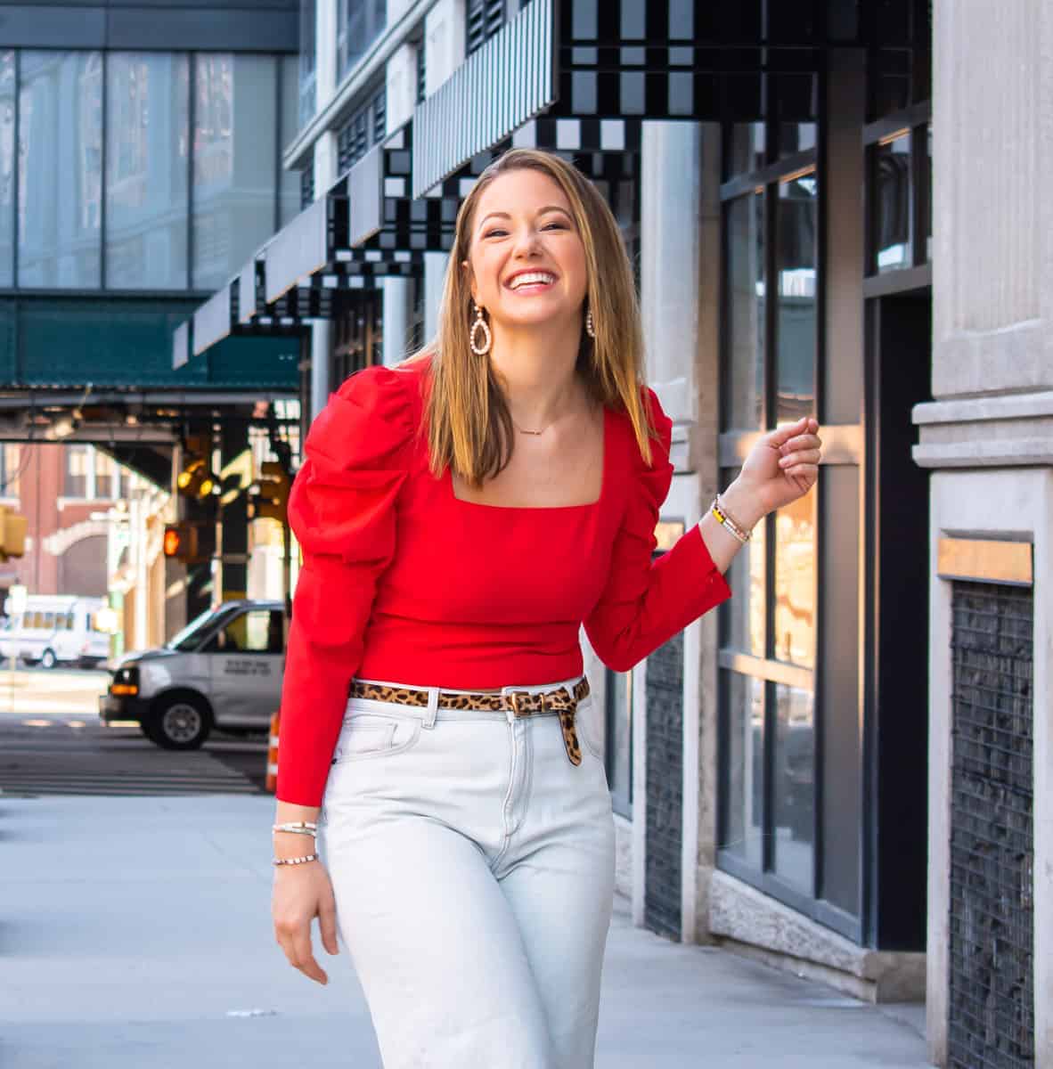 Red puff sleeve top by Alice and Olivia with whitewashed denim jeans and a leopard belt