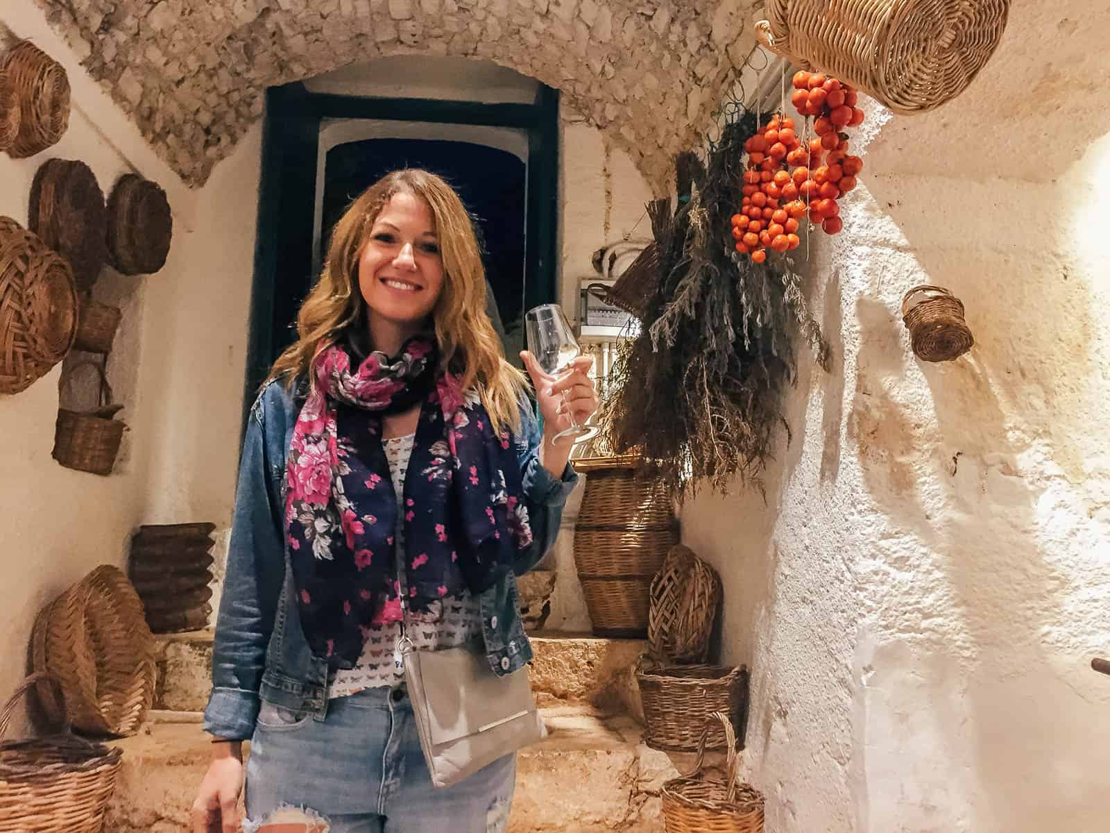 Woman drinking wine in the wine cellar at Masseria Il Frantoio in Puglia, Italy 