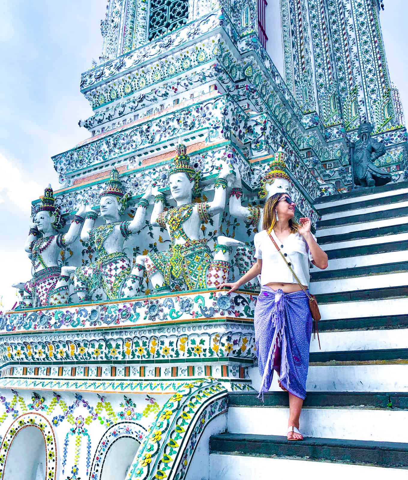 Woman walking down the steps of Wat Arun temple in Bangkok