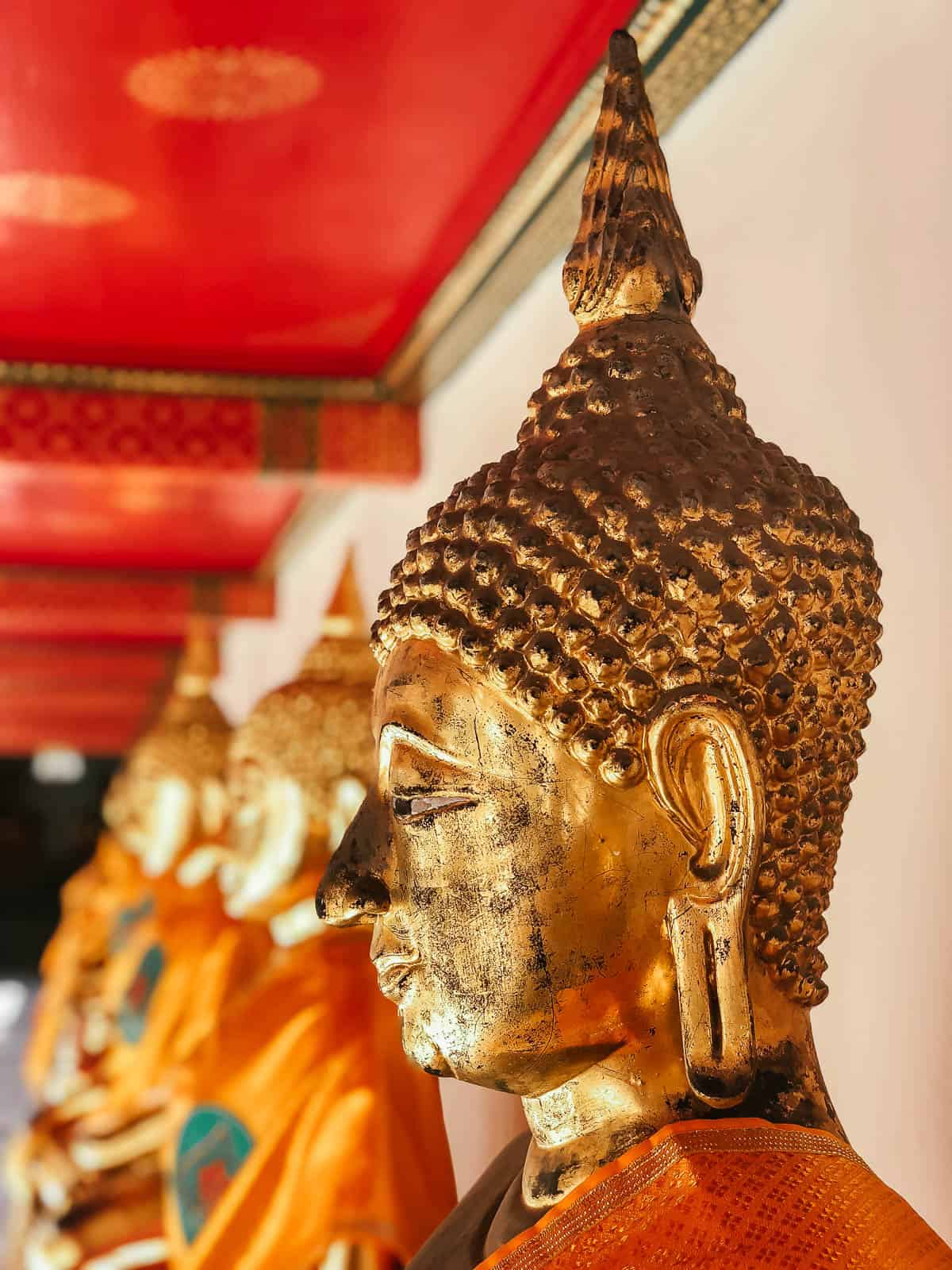 Row of gold buddha statues at Wat Pho temple in Bangkok