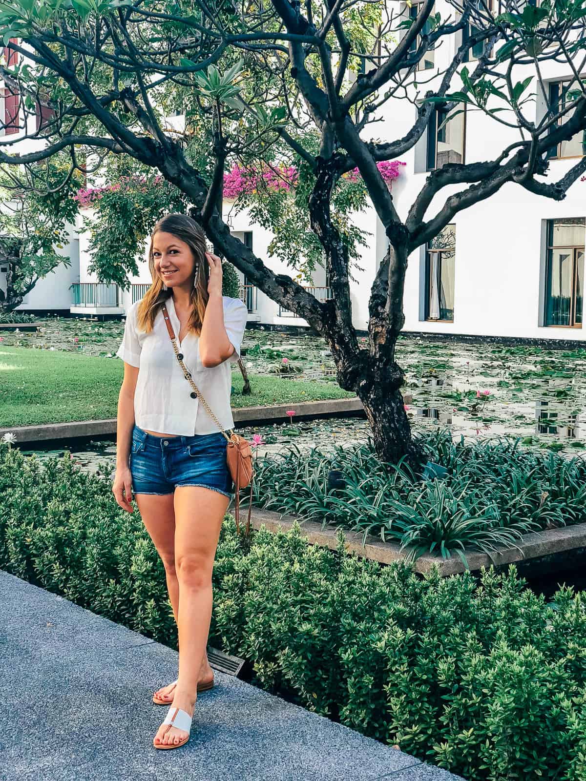 Woman standing next to a tree in the courtyard of the Sukhothai Bangkok hotel