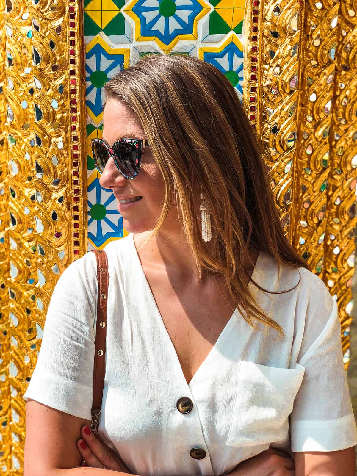 Woman in front of mosaic tile wall at the grand palace in bangkok