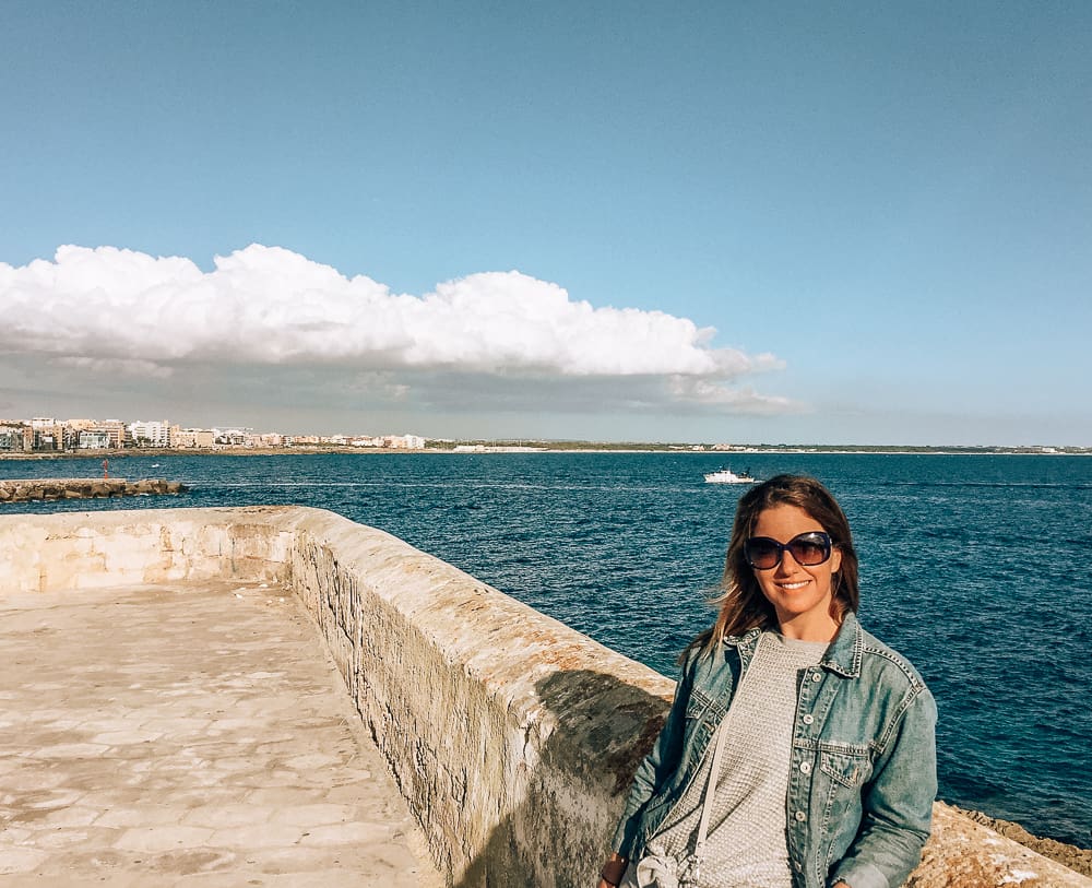 Woman standing by the water in Gallipoli, Puglia, Italy