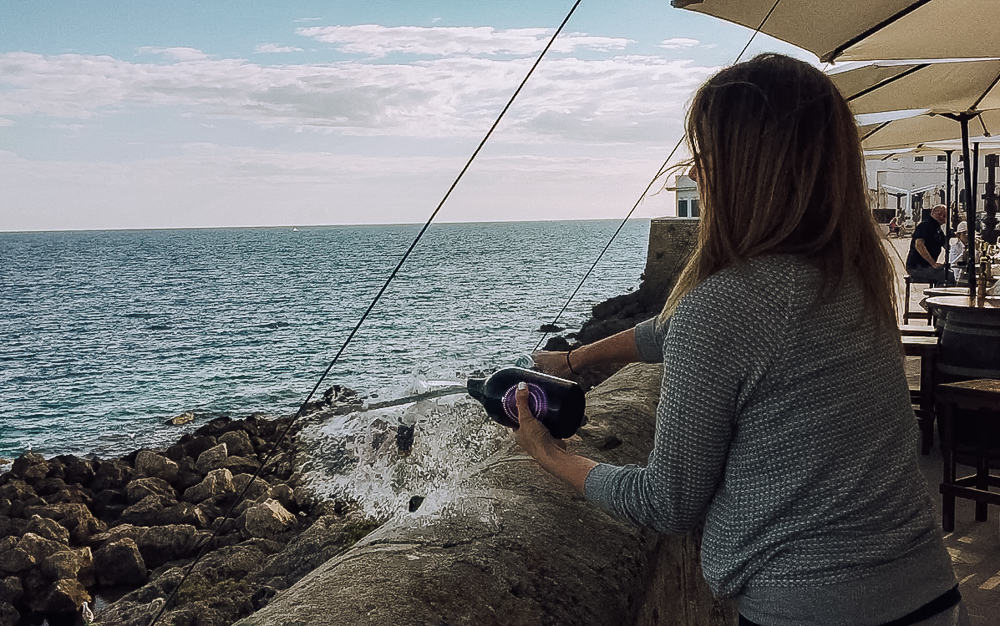 Woman sabering a champagne bottle at a wine bar in Gallipoli, Puglia