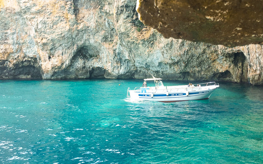 Boat outside Zinzulusa Caves in Puglia, Italy