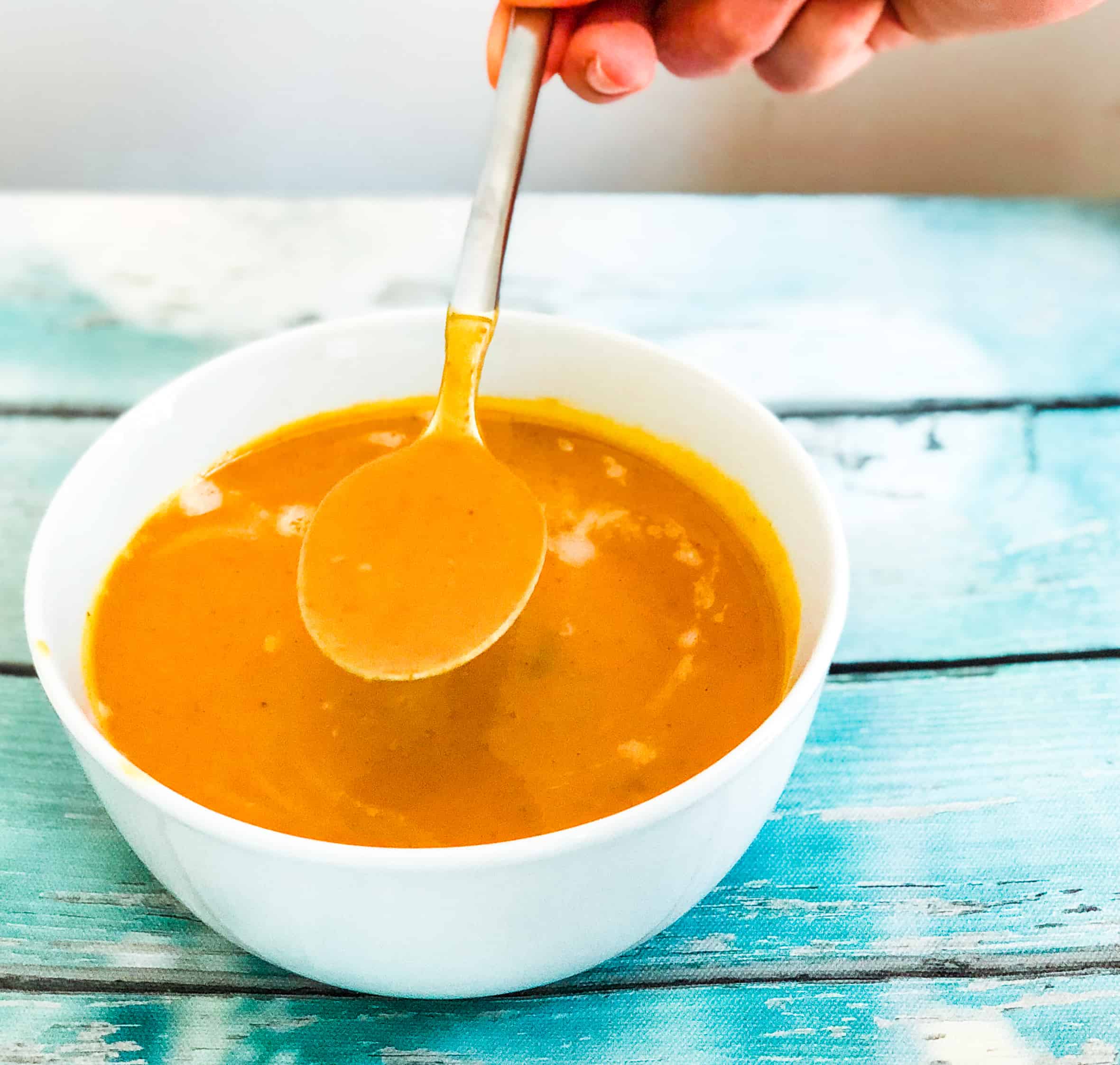 Bowl of curried butternut squash soup with a spoon 