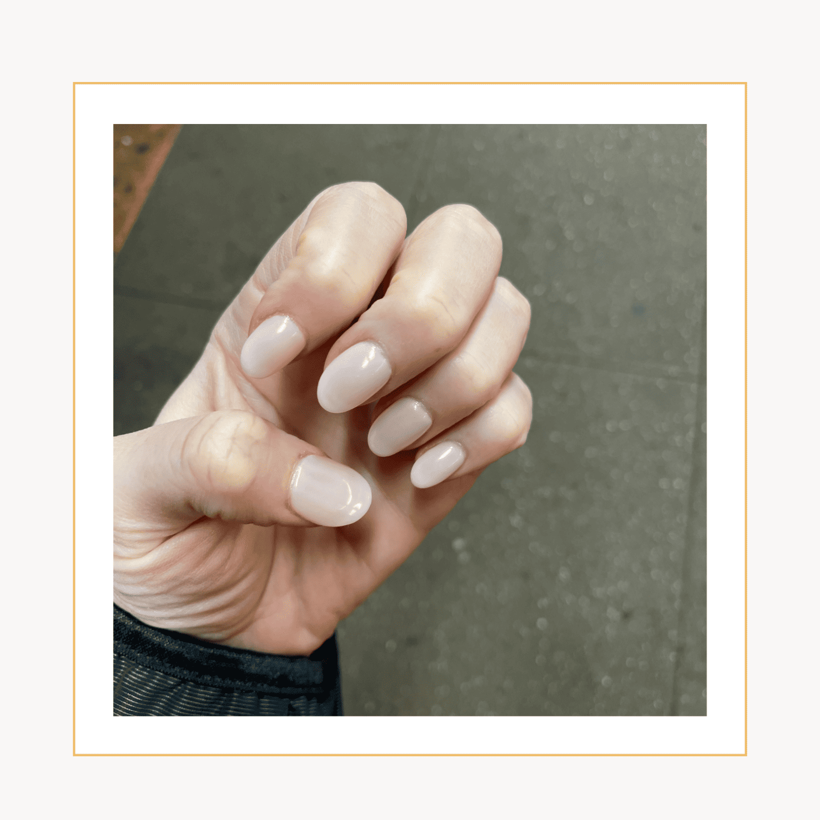 A women's hand showing Apres Gel-X nail extensions in a neutral light pink nail polish color. 