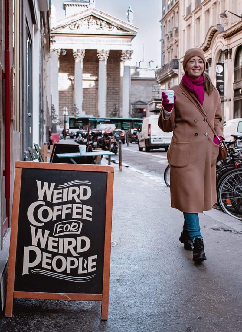 A woman outside a coffee shop in Paris